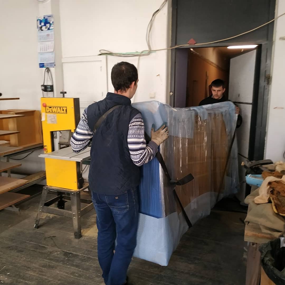 Грузчики поднимают диван на этаж